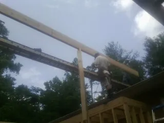 Carpenter setting a ridge beam over a new addition frame — Ice Dam Removal by Roofing Brothers in Wheatcroft