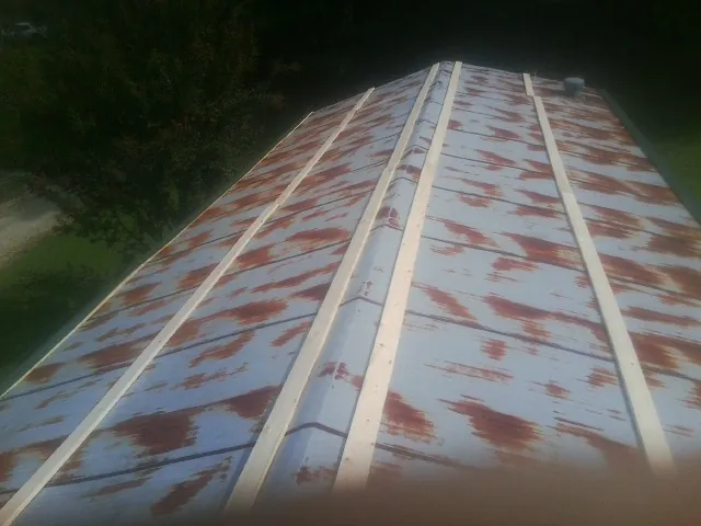 Rusted metal roof panels with new wood purlins before replacement — Storm Damage Roof Repair in Wheatcroft by Roofing Brothers