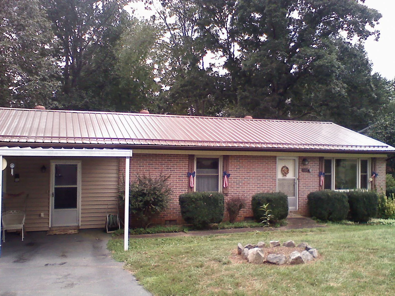 Bronze metal roof and carport on a brick ranch home — Roof Repair work by our crew in Wheatcroft